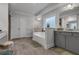 Bathroom with a tub, grey cabinets, stone countertops, tile floors and double doors at 3759 Chapel Cv, Douglasville, GA 30135