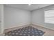 Neutral bedroom with light grey walls and carpet and a navy blue rug with light grey spots at 3759 Chapel Cv, Douglasville, GA 30135