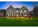Two-story home at dusk, with green lawn, landscape lighting, and manicured bushes at 3759 Chapel Cv, Douglasville, GA 30135