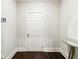Hallway with a white entry door, white walls, dark wood floor, and a mirrored table at 3759 Chapel Cv, Douglasville, GA 30135