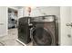 Modern laundry room with stainless steel washer and dryer and gray tile flooring at 3759 Chapel Cv, Douglasville, GA 30135