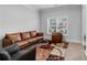 Cozy living room features a leather sofa, chair and colorful area rug at 3759 Chapel Cv, Douglasville, GA 30135