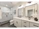 Contemporary bathroom with a glass-enclosed shower, double mirrors, and white marble countertop at 6178 Lake Lanier Heights Road, Buford, GA 30518