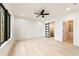 Bright bedroom featuring hardwood floors, a ceiling fan, and access to a walk-in closet and bathroom at 6178 Lake Lanier Heights Road, Buford, GA 30518