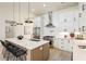 Bright open kitchen with stainless appliances, a spacious island with seating, and stylish pendant lights at 6178 Lake Lanier Heights Road, Buford, GA 30518