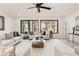 Bright living room with large windows overlooking nature, ceiling fan, and neutral decor at 6178 Lake Lanier Heights Road, Buford, GA 30518