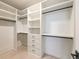 Spacious walk-in closet featuring custom shelving, drawers, and ample storage space at 6178 Lake Lanier Heights Road, Buford, GA 30518