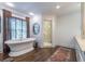 Modern bathroom featuring a soaking tub, glass shower, and hardwood floors at 690 Old Ivy Ne Rd, Atlanta, GA 30342