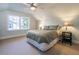 Bright bedroom featuring a ceiling fan, a large window, neutral colored carpet and fresh blue paint at 690 Old Ivy Ne Rd, Atlanta, GA 30342