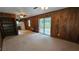 A spacious living room boasts wood paneling, a ceiling fan, and direct access to the outdoor patio through sliding glass doors at 4112 Bontura Ct, Stone Mountain, GA 30083