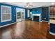 Beautifully staged living room with dark blue walls, hardwood floors, fireplace, and access to an outdoor patio at 4954 Wyeth Way, Alpharetta, GA 30022