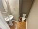 Cozy powder room with pedestal sink, wood floors and modern fixtures at 4954 Wyeth Way, Alpharetta, GA 30022