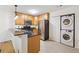 Bright kitchen with stainless steel appliances, granite counters, light wood cabinetry, and in-unit laundry at 1445 Monroe Ne Dr # A12, Atlanta, GA 30324
