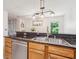 Open concept kitchen featuring a stainless steel dishwasher, granite countertops and modern light fixture at 1445 Monroe Ne Dr # A12, Atlanta, GA 30324