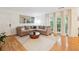 Bright living area with hardwood floors, a cozy sectional, and outdoor views at 1445 Monroe Ne Dr # A12, Atlanta, GA 30324