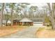Inviting single-story brick home with mature trees and a long driveway leading to the attached garage at 3261 Hidden Forest Dr, Snellville, GA 30078
