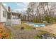 Backyard view of a home with a screened porch, concrete patio, and an in-ground swimming pool with a surrounding concrete deck at 3261 Hidden Forest Dr, Snellville, GA 30078