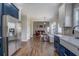 Modern kitchen featuring blue cabinets, stainless steel appliances, and a seamless flow to living area at 20 Alison Trail, Covington, GA 30014