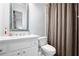 Well-lit bathroom with a modern vanity, toilet, and a shower featuring a neutral-toned curtain at 3150 Shumard Way, Marietta, GA 30064