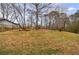 A grassy backyard with tall trees and a wooden fence at 3310 Forest Creek Sw Dr, Marietta, GA 30064