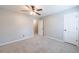A neutral carpeted bedroom featuring a window and a white door at 3310 Forest Creek Sw Dr, Marietta, GA 30064