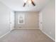 A neutral carpeted bedroom featuring a window and two white doors at 3310 Forest Creek Sw Dr, Marietta, GA 30064