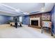 Finished basement featuring a brick fireplace, game area, pinball machine, and blue painted walls at 656 Gunby Se Rd, Marietta, GA 30067