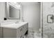 Modern bathroom features a gray vanity with a white countertop and a decorative mirror at 656 Gunby Se Rd, Marietta, GA 30067
