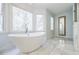 Bright and airy bathroom with a modern standalone tub and floor-to-ceiling windows at 656 Gunby Se Rd, Marietta, GA 30067