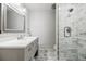 Stylish bathroom showcases a marble tiled shower and a vanity with a decorative mirror at 656 Gunby Se Rd, Marietta, GA 30067