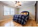Charming bedroom with hardwood floors, ceiling fan, and large window at 656 Gunby Se Rd, Marietta, GA 30067