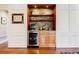 Stylish beverage bar with stone backsplash, wooden shelves, and a wine refrigerator at 656 Gunby Se Rd, Marietta, GA 30067