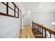 Bright hallway with hardwood floors, crown molding, and wrought iron railing at 656 Gunby Se Rd, Marietta, GA 30067