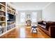 Bright living room featuring hardwood floors, a built-in bookcase, and a comfortable leather sofa at 656 Gunby Se Rd, Marietta, GA 30067