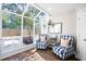 Light-filled sunroom with floor-to-ceiling windows, cozy seating, and a tranquil view of the backyard at 95 Mount Vernon Cir, Atlanta, GA 30338