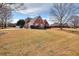 Brick home with a well-manicured front lawn and mature trees creating an inviting curb appeal at 1500 Elena Dr, Mcdonough, GA 30253