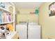 Functional laundry room with washer, dryer, and shelving for supplies at 1500 Elena Dr, Mcdonough, GA 30253