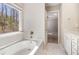 Bathroom featuring tub, a window, and white cabinets at 196 Foggy Creek Lane Ln, Hiram, GA 30141