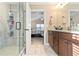 Bathroom showcasing a glass enclosed walk-in shower, dual sink vanity, and doorway to the main bedroom at 316 Cranmore Pl, Villa Rica, GA 30180
