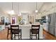 Open kitchen featuring a large island, granite countertops, stainless steel appliances, and hardwood floors at 316 Cranmore Pl, Villa Rica, GA 30180