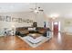 Spacious living room featuring a large leather sectional, hardwood floors, and a ceiling fan at 316 Cranmore Pl, Villa Rica, GA 30180