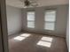 Bedroom featuring neutral walls, ceiling fan and light, two windows, and carpet flooring at 722 Thornapple Trl, Lawrenceville, GA 30046