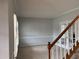 Light-filled room with neutral walls, white trim, and carpet flooring, accented by a charming staircase at 722 Thornapple Trl, Lawrenceville, GA 30046
