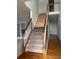 Inviting carpeted staircase with wooden banister and white spindles leads to the upper level at 722 Thornapple Trl, Lawrenceville, GA 30046