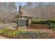 A welcoming community clubhouse entrance with stone accents and blooming flowers at 11910 Wildwood Springs Dr, Roswell, GA 30075