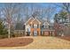 Traditional brick home with black shutters, manicured lawn, and a large front window at 11910 Wildwood Springs Dr, Roswell, GA 30075