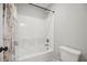 Well-lit bathroom featuring a standard bathtub with a shower head and neutral colored shower curtain at 1511 New Hope Rd, Locust Grove, GA 30248