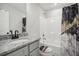 Bathroom featuring a shower-tub combo with decorative black and gold shower curtain and a granite sink at 1511 New Hope Rd, Locust Grove, GA 30248