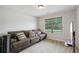 Comfortable living room with a plush brown sectional couch and a large window with natural lighting at 1511 New Hope Rd, Locust Grove, GA 30248