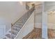 Elegant staircase featuring wood steps, iron railing, and classic wall paneling at 1511 New Hope Rd, Locust Grove, GA 30248